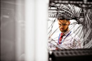 Technician checking cables in a rack mounted server